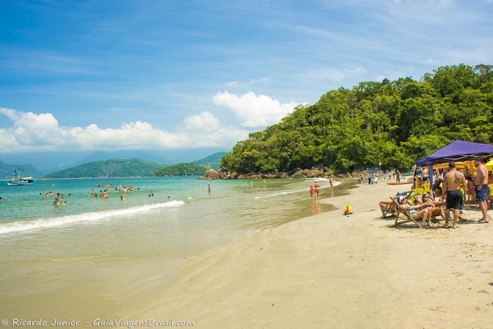 Imagem de um dia de sol com praia cheia de gente bonita.